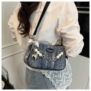 Détail du sac à bandoulière en jean avec nœud argenté et chaîne florale en perles