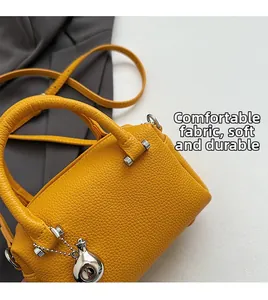 Vue détaillée de la texture du cuir grainé jaune vif sur ce sac Boston