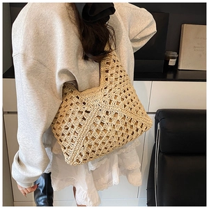 Detail of hand-woven beige crochet tote bag showing intricate hollow-out texture