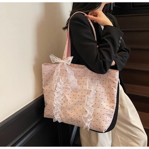 Détail du cabas rose à pois avec nœud en dentelle blanche et texture en maille à volants