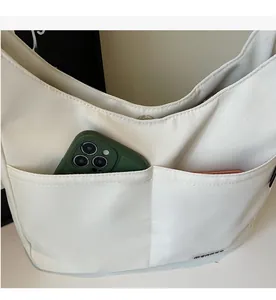 Detail of white canvas hobo bag showing external pockets and spacious interior storage