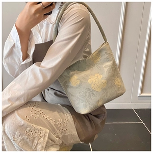 Detail of light green floral jacquard shoulder bag showing textured woven fabric