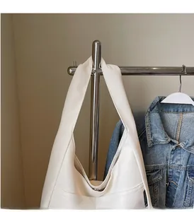 Detail view of white canvas tote bag with front pocket and durable wide shoulder strap