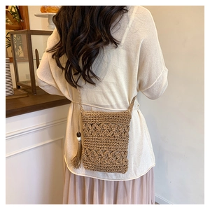Detail of woven bucket bag featuring decorative tassels and natural wooden beads
