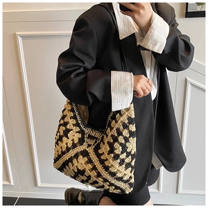 Detail of handwoven black and beige crochet tote bag with geometric diamond pattern