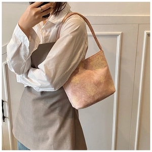Close-up of pink bucket bag with yellow floral jacquard pattern and matching shoulder strap