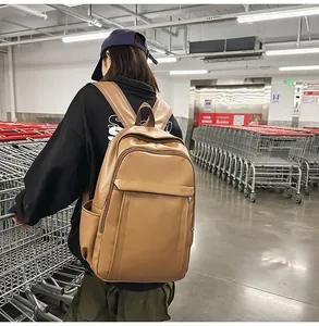 Detail view of a stylish camel PU leather backpack featuring multiple storage pockets