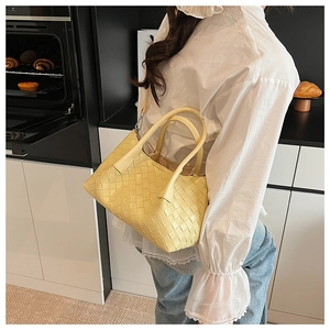Détail du sac cabas tissé jaune clair en cuir avec anses larges et doublure en toile