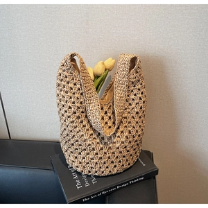 Detail of hollow woven straw tote bag with fabric lining and bohemian texture style