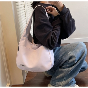 Detail of light purple hobo bag featuring Merrey logo tag and side zipper pocket