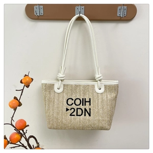 Detail of beige straw tote bag with white leather straps and black COIH 2DN embroidery