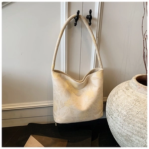 Detail of elegant cream-white jacquard shoulder bag with delicate yellow floral patterns