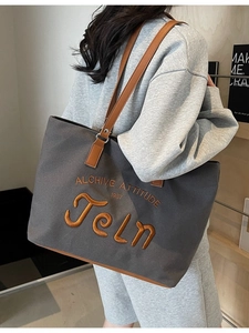 Minimalist canvas tote bag with letter embroidery and leather handles for daily commute