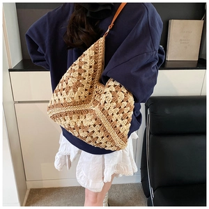 Detail of bohemian handmade straw tote with two-tone crochet patterns and leather strap