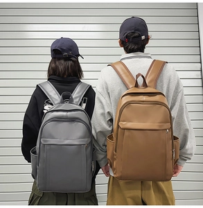 Detail view of large grey and brown PU leather backpacks for urban daily commuting