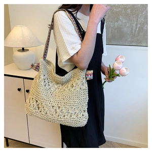 Detailed close-up of beige crochet tote bag with floral patterns and ethnic style shoulder strap