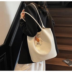 Detail of off-white leather tote bag with woven texture and tricolor Pegasus charm