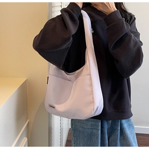 Detail of light purple canvas tote bag featuring large front pocket and Merrey brand logo