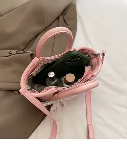 Detail view of pink bucket bag showing interior space for cosmetics and pearl lace trim