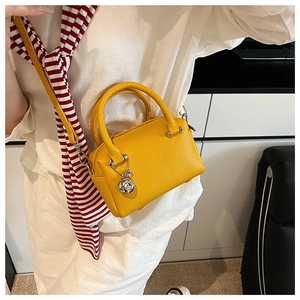 Sac Boston jaune en cuir grainé avec pendentif rose argentée et bandoulière amovible