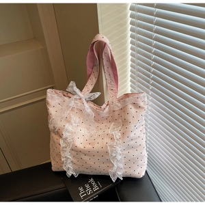 Détail du sac cabas rose à pois avec bordure en dentelle et grand nœud décoratif