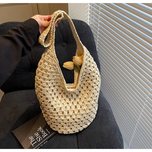 Close-up of beige woven hobo shoulder bag on a blue chair with shadow play