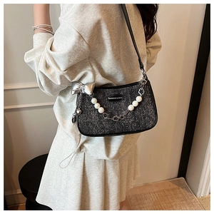Vue détaillée du sac à bandoulière noir pailleté avec bandoulière en perles et nœud argenté