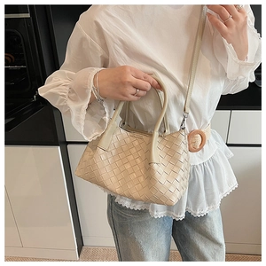 Détail de la texture tressée beige du sac à main en cuir avec bandoulière amovible