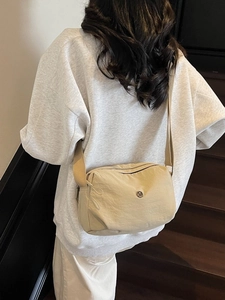 Sac bandoulière en tissu beige avec large sangle et logo, style de mode été minimaliste