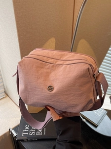 Sac bandoulière minimaliste en nylon rose avec plusieurs poches et sangle large