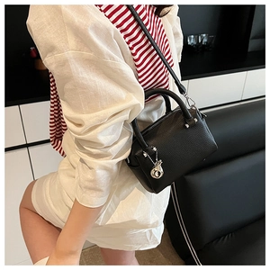 Détail du mini sac Boston en cuir noir grainé avec pendentif escargot argenté et poignées