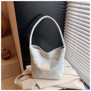 Detailed close-up of a floral canvas bucket bag with elegant yellow flower patterns