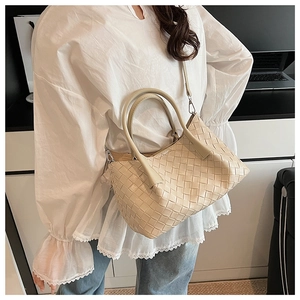 Détail du sac cabas beige tressé avec texture Intrecciato et bandoulière amovible