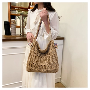 Detailed straw woven tote bag with hollow flower texture and colorful boho strap