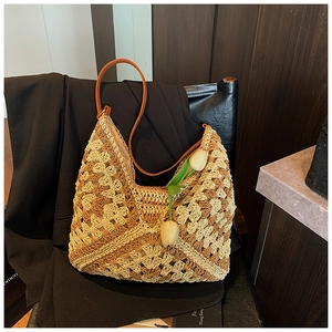 Detail of crochet straw tote bag with geometric color blocks and leather strap