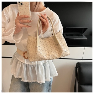 Détail d'un sac seau crème tressé à la main avec texture artisanale Intrecciato de qualité
