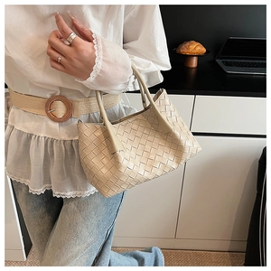 Détail du sac à main tressé beige avec texture Intrecciato et doubles poignées chic