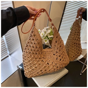 Close-up of bohemian woven straw tote bag with intricate patterns and leather strap