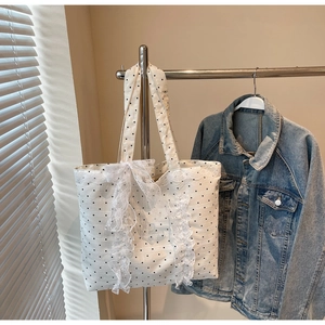 Détail d'un sac cabas à pois blancs avec dentelle fine et nœud ruban élégant