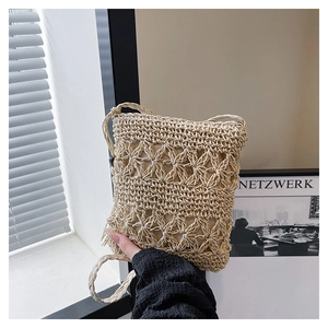 Detailed view of beige hand-woven crochet bucket bag with star patterns and tassel trim