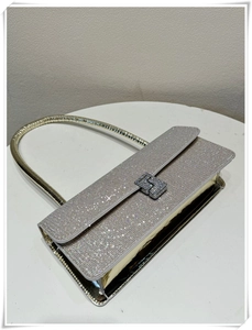 Close-up of silver rhinestone handbag featuring a sparkling crystal H-shaped metal buckle