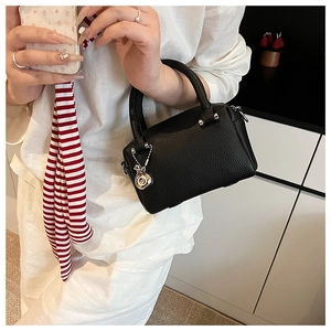 Détail du sac Boston en cuir grainé noir avec fermeture éclair argentée et foulard en soie