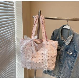 Détail du sac cabas rose à pois avec des volants en dentelle blanche et un grand nœud