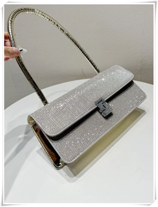 Detail view of a silver rhinestone evening bag with sparkling gems and a metal handle