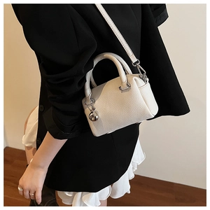 Vue détaillée du mini sac Boston blanc texturé avec pendentif sphérique argenté