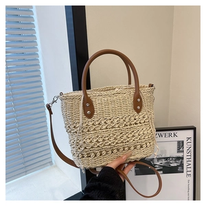 Detail view of woven straw bucket bag with leather handles and drawstring lining