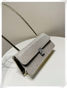 Close-up of sparkling silver rhinestone shoulder bag with fine metal handle and crystal buckle