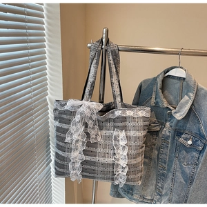 Détail du cabas à carreaux gris avec bordure en dentelle blanche et grand nœud chic