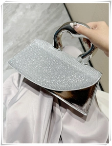 Close-up of sparkling silver rhinestone handbag with elegant curved metal handle