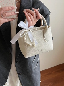 Chic cream bucket bag with lychee texture featuring silk bow and pearl charm for women